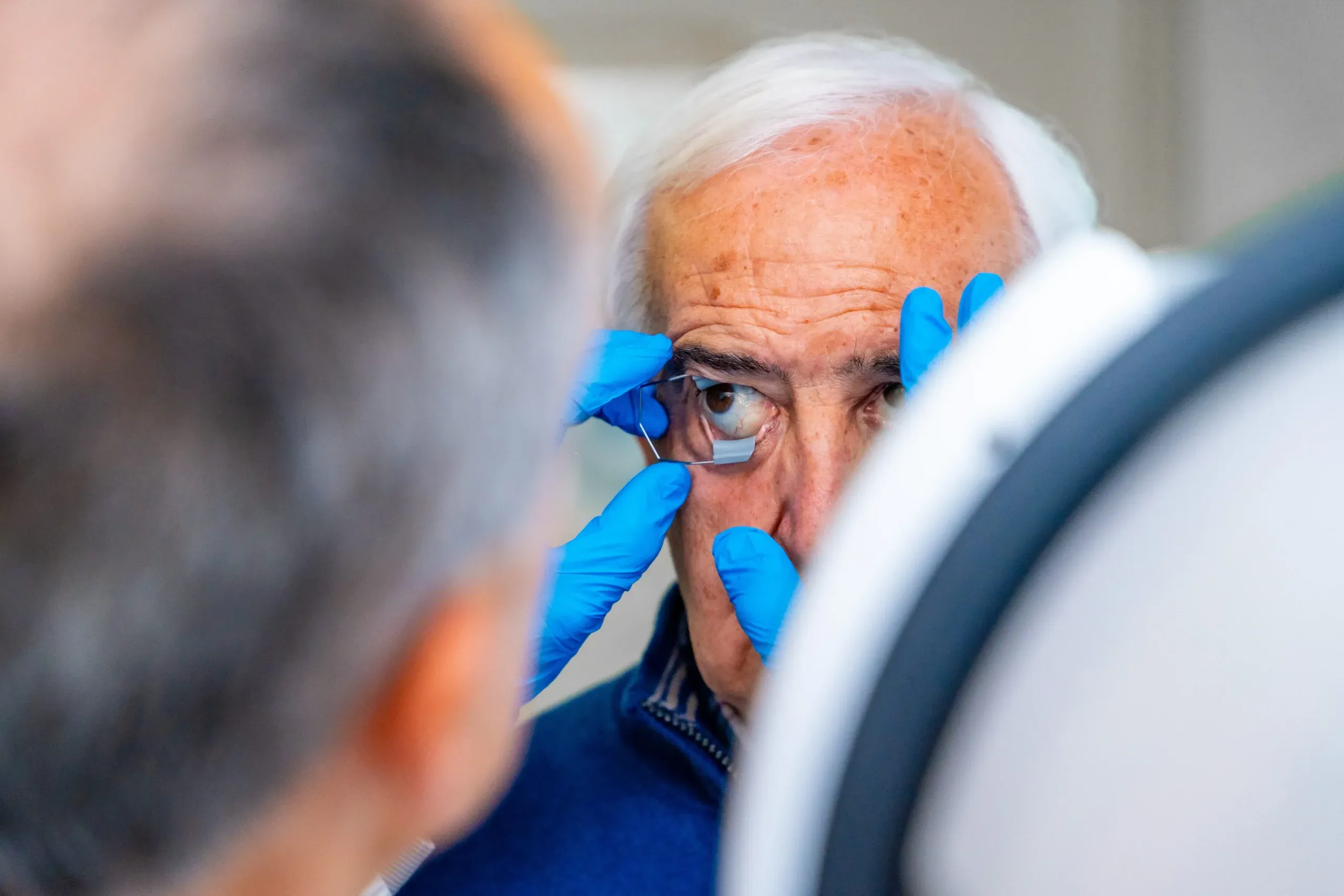 Ophthalmologist consulting a senior couple in an eye hospital consultation room