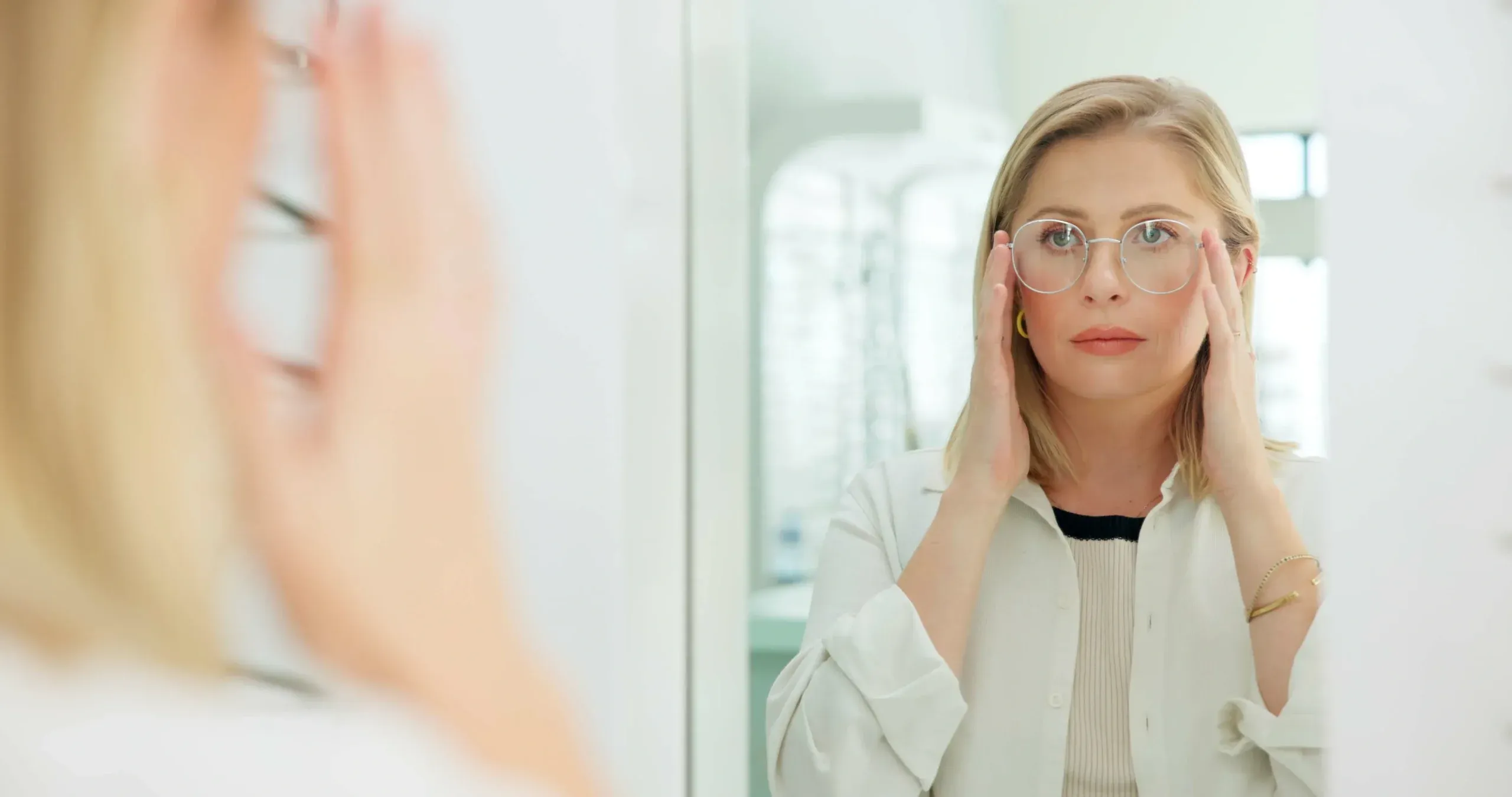 Woman holding eyeglasses and experiencing worsening vision, with an eye chart in the background and eye-care information about possible vision problems.